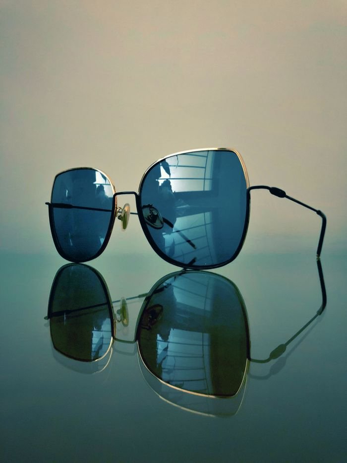 pexels photo 2659705 2659705 Close-up of modern sunglasses with reflective lenses on a smooth surface.