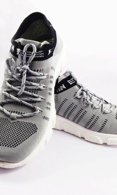 Detailed close-up of stylish grey sneakers, perfect for sports and casual wear on a white background.