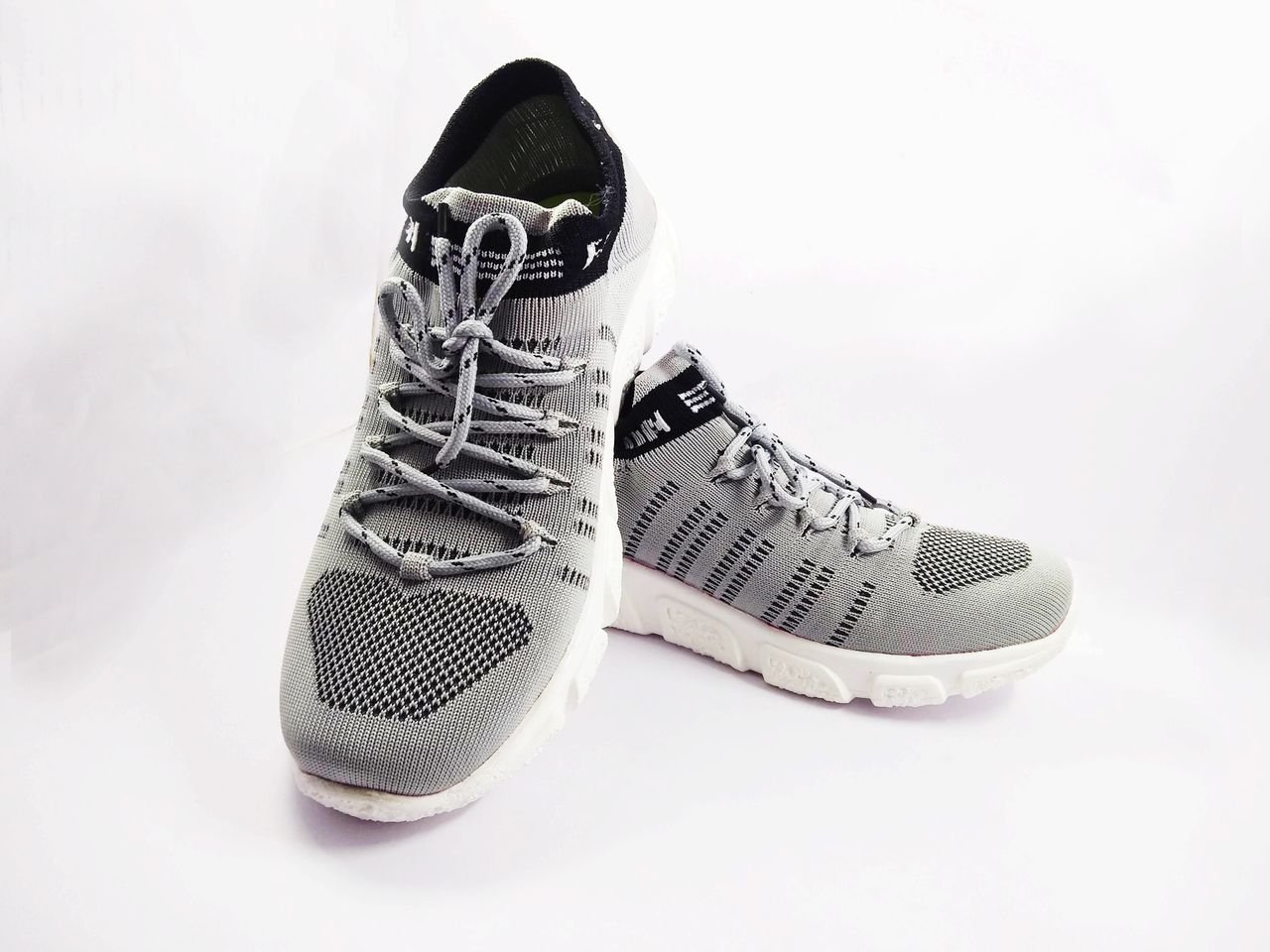 Detailed close-up of stylish grey sneakers, perfect for sports and casual wear on a white background.
